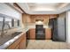 Kitchen with granite countertops, black appliances and light wood cabinets at 2048 Los Lomas Dr, Clearwater, FL 33763