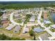Neighborhood aerial showcasing houses nestled among mature trees, lakes, and a golf course at 2258 Preservation Green Ct, Sun City Center, FL 33573