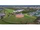 Overhead view of a well-maintained baseball field, tennis courts, and pond in the community at 2258 Preservation Green Ct, Sun City Center, FL 33573