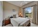 Bedroom with large window view, small side table and decorative window treatments at 2258 Preservation Green Ct, Sun City Center, FL 33573