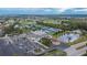 Aerial shot of the community center, tennis courts, and parking lot near a pond with water lilies at 2258 Preservation Green Ct, Sun City Center, FL 33573