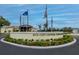 A welcoming community entrance with flags, manicured landscaping and a view of a fountain on a scenic pond at 2258 Preservation Green Ct, Sun City Center, FL 33573