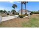 Exterior view showing home with a two-car garage, complemented by manicured landscaping and lush palm trees at 2258 Preservation Green Ct, Sun City Center, FL 33573
