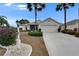 Charming home with well-manicured landscaping and a spacious two-car garage, complemented by lush palm trees at 2258 Preservation Green Ct, Sun City Center, FL 33573