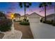 Twilight view of home, complemented by lush palm trees and manicured landscaping with a cozy curb appeal at 2258 Preservation Green Ct, Sun City Center, FL 33573