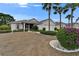 Beautiful home exterior with lush landscaping, a well-manicured lawn, and mature trees for enhanced curb appeal at 2258 Preservation Green Ct, Sun City Center, FL 33573