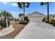 Charming home with well-manicured landscaping and a spacious two-car garage, complemented by lush palm trees at 2258 Preservation Green Ct, Sun City Center, FL 33573
