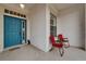 Charming front porch with a vibrant blue door, red chairs, and a welcoming mat, offering a cozy entrance at 2258 Preservation Green Ct, Sun City Center, FL 33573