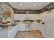 Classic kitchen with white appliances, tile flooring and decorative wallpaper accents at 2258 Preservation Green Ct, Sun City Center, FL 33573