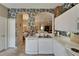 View of white kitchen featuring updated appliances and decorative floral wallpaper at 2258 Preservation Green Ct, Sun City Center, FL 33573