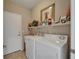 Laundry room featuring a washer, dryer, and storage shelves for convenience at 2258 Preservation Green Ct, Sun City Center, FL 33573