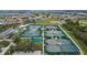 Overhead view of outdoor tennis courts in an active community with mature trees at 2258 Preservation Green Ct, Sun City Center, FL 33573