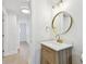 Bathroom features gold fixtures, a round mirror, and a wood cabinet at 3106 Ash Ct, Dunedin, FL 34698