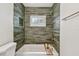 Bathtub with green tile surround and gold fixtures provides a modern look at 3106 Ash Ct, Dunedin, FL 34698