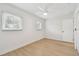 Bedroom with light wood floors, base molding, two windows and a ceiling fan at 3106 Ash Ct, Dunedin, FL 34698