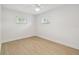 Bedroom with new flooring, baseboards, a ceiling fan, and two windows at 3106 Ash Ct, Dunedin, FL 34698