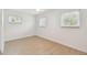 Bright bedroom with wood floors, base molding, and three windows at 3106 Ash Ct, Dunedin, FL 34698