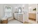 Bright dressing area features soft tones, a vanity with a large mirror, and natural light from a window at 3106 Ash Ct, Dunedin, FL 34698