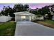 Inviting single-story home featuring a freshly painted driveway and serene landscaping at 3106 Ash Ct, Dunedin, FL 34698