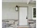 Close up of the front door featuring a new light fixture, paint and stone accents at 3106 Ash Ct, Dunedin, FL 34698