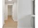 Bright hallway with light colored wood floors and white doors at 3106 Ash Ct, Dunedin, FL 34698