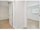 Hallway with wood floors leads to an open bedroom with large window at 3106 Ash Ct, Dunedin, FL 34698