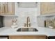 Close-up of a kitchen sink featuring a gooseneck faucet, white subway tile backsplash, and quartz countertop at 3106 Ash Ct, Dunedin, FL 34698