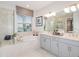 Luxurious bathroom featuring a soaking tub, walk-in shower, and double vanity sinks at 33284 Castaway Loop, Wesley Chapel, FL 33543