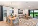 Open-concept living and dining area with modern furnishings and access to the outdoor patio at 33284 Castaway Loop, Wesley Chapel, FL 33543