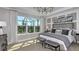 Serene main bedroom with tray ceilings, large windows, and stylish decor at 33284 Castaway Loop, Wesley Chapel, FL 33543