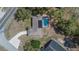 Birds eye view of the home with a screen enclosed pool and long driveway at 3344 Blythe Ave, Spring Hill, FL 34609