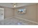 This bedroom features beautiful marble floors, a ceiling fan, fresh paint, and lots of natural light at 3344 Blythe Ave, Spring Hill, FL 34609