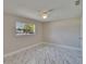 Bedroom features ceiling fan, window with neighborhood views, and marble flooring at 3344 Blythe Ave, Spring Hill, FL 34609