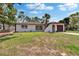 This home features a charming exterior, a well-maintained lawn, and a palm tree, blending comfort and style at 3344 Blythe Ave, Spring Hill, FL 34609