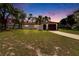 A warm sunset complements this cozy home, featuring an arched entry and manicured landscaping at 3344 Blythe Ave, Spring Hill, FL 34609