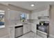 Bright kitchen features white cabinets, stainless steel appliances, quartz countertops, and stylish marble flooring at 3344 Blythe Ave, Spring Hill, FL 34609