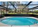 Relaxing screened pool area with an inviting oval in-ground pool, perfect for cooling off on hot days, all surrounded by lush greenery at 3344 Blythe Ave, Spring Hill, FL 34609