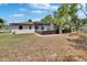 Backyard view featuring a screened-in pool, ideal for private outdoor relaxation and recreation, with ample lawn space at 3344 Blythe Ave, Spring Hill, FL 34609