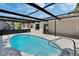 Screened-in pool featuring a refreshing, turquoise water and black metal enclosure in a backyard setting at 3344 Blythe Ave, Spring Hill, FL 34609