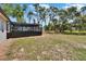 Backyard view featuring a screened-in pool, perfect for outdoor relaxation and recreation, with a backdrop of mature trees at 3344 Blythe Ave, Spring Hill, FL 34609