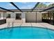 Inviting screened pool area featuring a sparkling pool and a covered patio area, ideal for relaxation and entertainment at 3344 Blythe Ave, Spring Hill, FL 34609