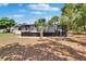 Backyard view featuring a screened-in pool, perfect for private outdoor relaxation and enjoyment, enhanced by lush lawn at 3344 Blythe Ave, Spring Hill, FL 34609