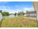A spacious grassy backyard featuring a screened in patio overlooking the water at 3431 Springfield Dr, Holiday, FL 34691