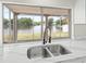 Kitchen sink with a large window that offers a scenic view of the lake and backyard at 3431 Springfield Dr, Holiday, FL 34691