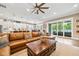 Open-concept living room with large leather sofa, wood coffee table, and access to kitchen and patio at 3611 W Royal Palm Cir, Tampa, FL 33629