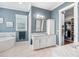 Bright main bathroom featuring a soaking tub, dual vanity sinks, and a walk-in closet at 3611 W Royal Palm Cir, Tampa, FL 33629