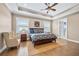 Spacious main bedroom with tray ceiling, fan, and plenty of natural light from the windows at 3611 W Royal Palm Cir, Tampa, FL 33629