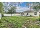 Lush backyard with a wooden deck, views of the home, and a surrounding fence at 3876 Crossline Dr, Spring Hill, FL 34609