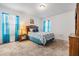 Cozy bedroom with coordinated blue bedspread and curtains, complemented by hardwood furniture and a neutral carpet at 3876 Crossline Dr, Spring Hill, FL 34609