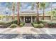 Beautiful clubhouse entrance with palm trees, landscaping and a walkway leading up to the building at 3876 Crossline Dr, Spring Hill, FL 34609